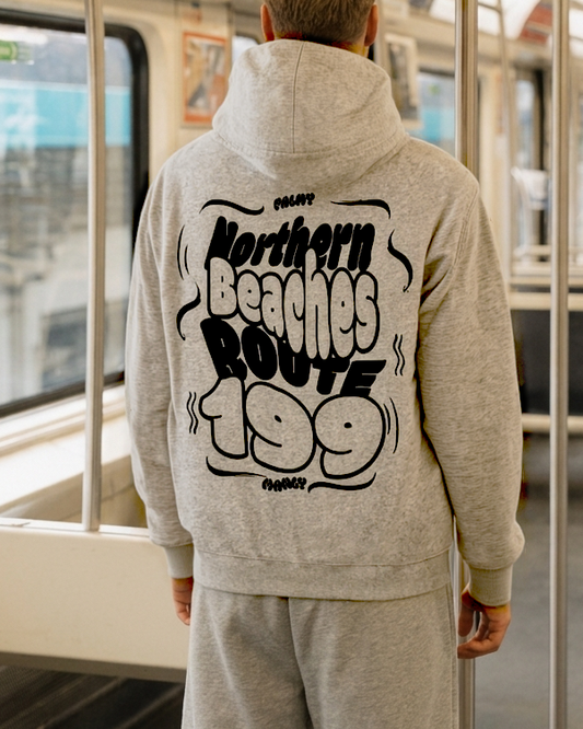 Person wearing a gray hoodie with text on the back inside a subway car.