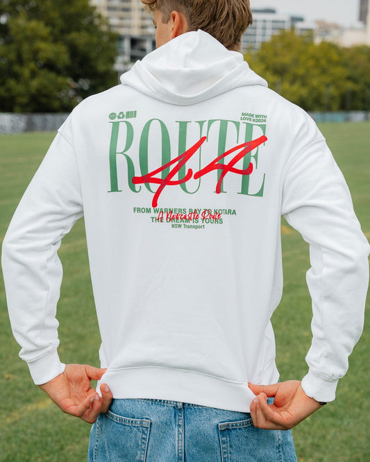 Person wearing a white hoodie with green and red text in an outdoor setting