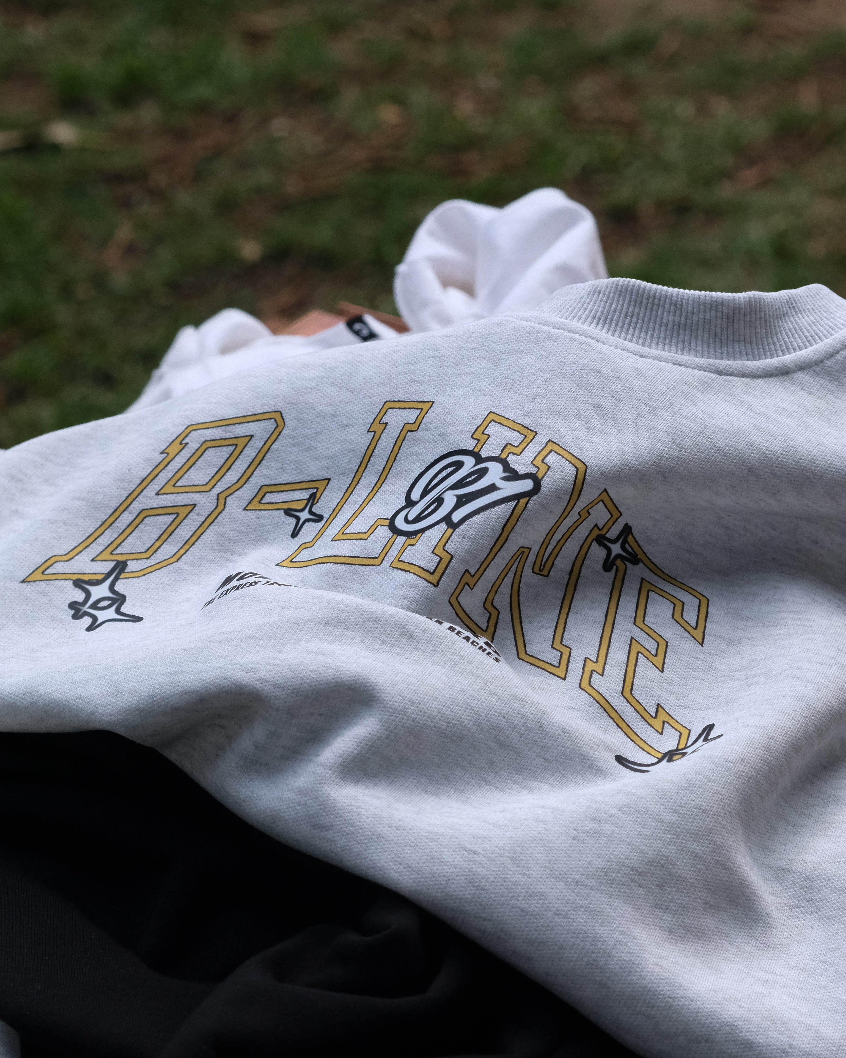 Gray sweatshirt with 'B-Line' logo on grass