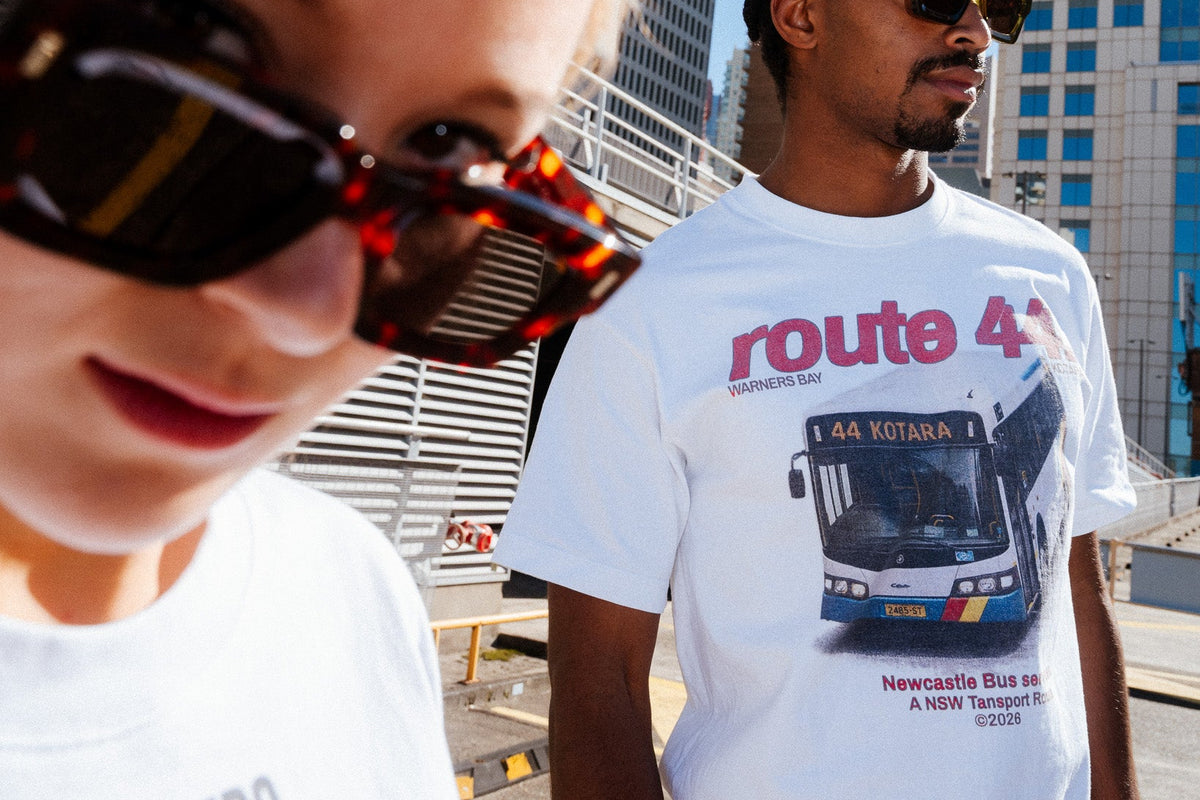 Two people wearing sydney transport t-shirts with a cityscape background